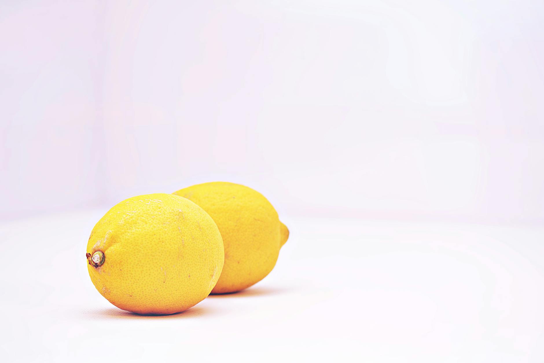 Bright yellow lemons arranged on a pastel green background, representing freshness and renewal in midlife intimacy.